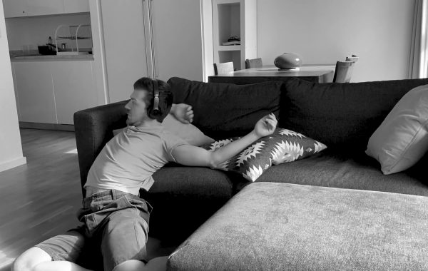 Black and white photo of a man sliding off his sofa