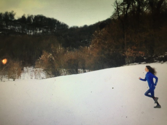 A woman running through a snowy field