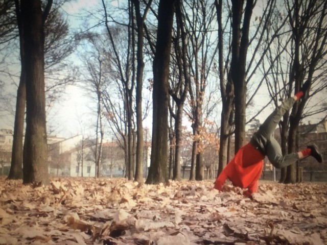 A person doing a cartwheel in autumn leaves