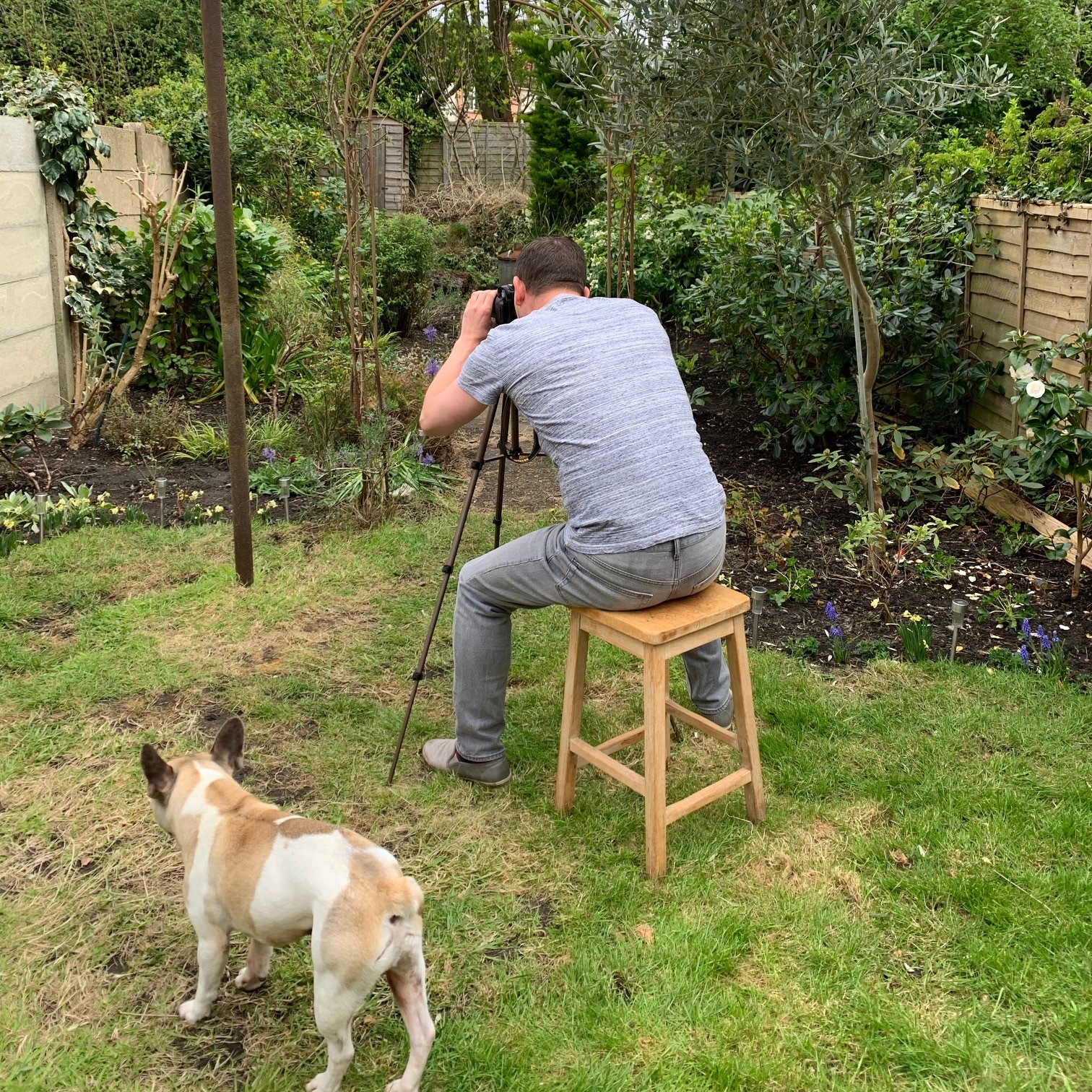 Peter Meager taking a photo in his garden with his dog