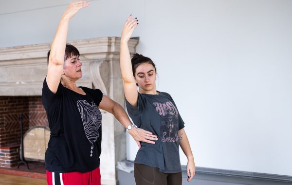 Dance For Wellbeing. A dance teacher corrects a student's position during a dance class