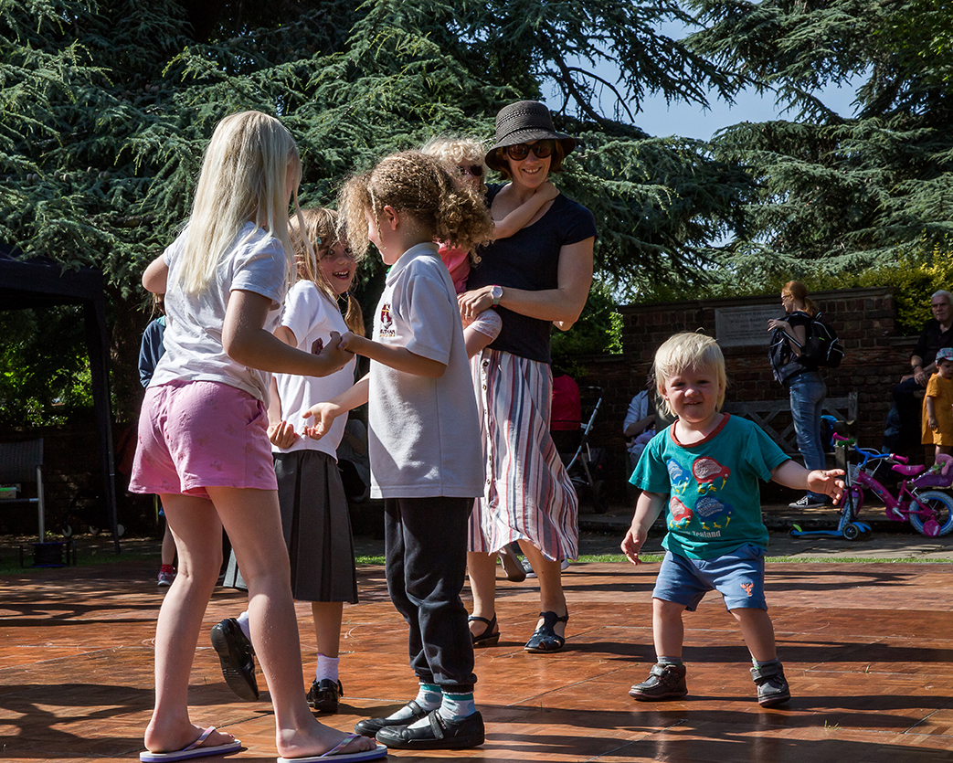 Family Story Walks. A group of children dance together in a group