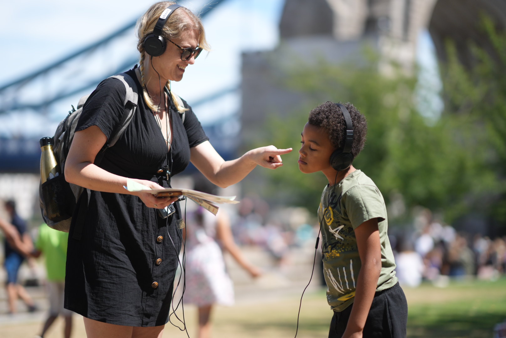 MidSummerland. A woman and a child wearing headphones. The woman is pointing at the child's face