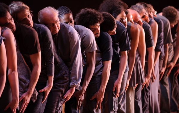 30 years in pictures: Common Dance. A line of participants stand with their heads on each others shoulders